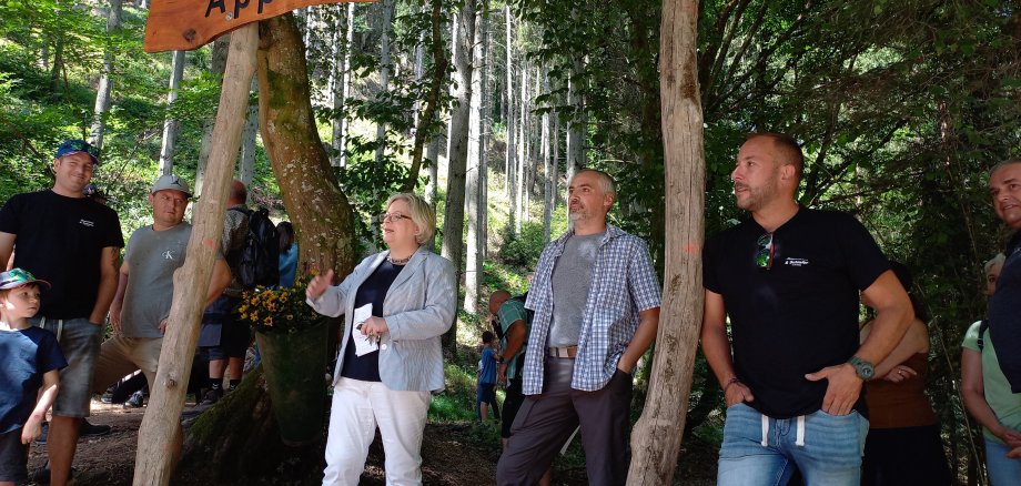 Personen stehen bei einer Wanderwegeröffnung