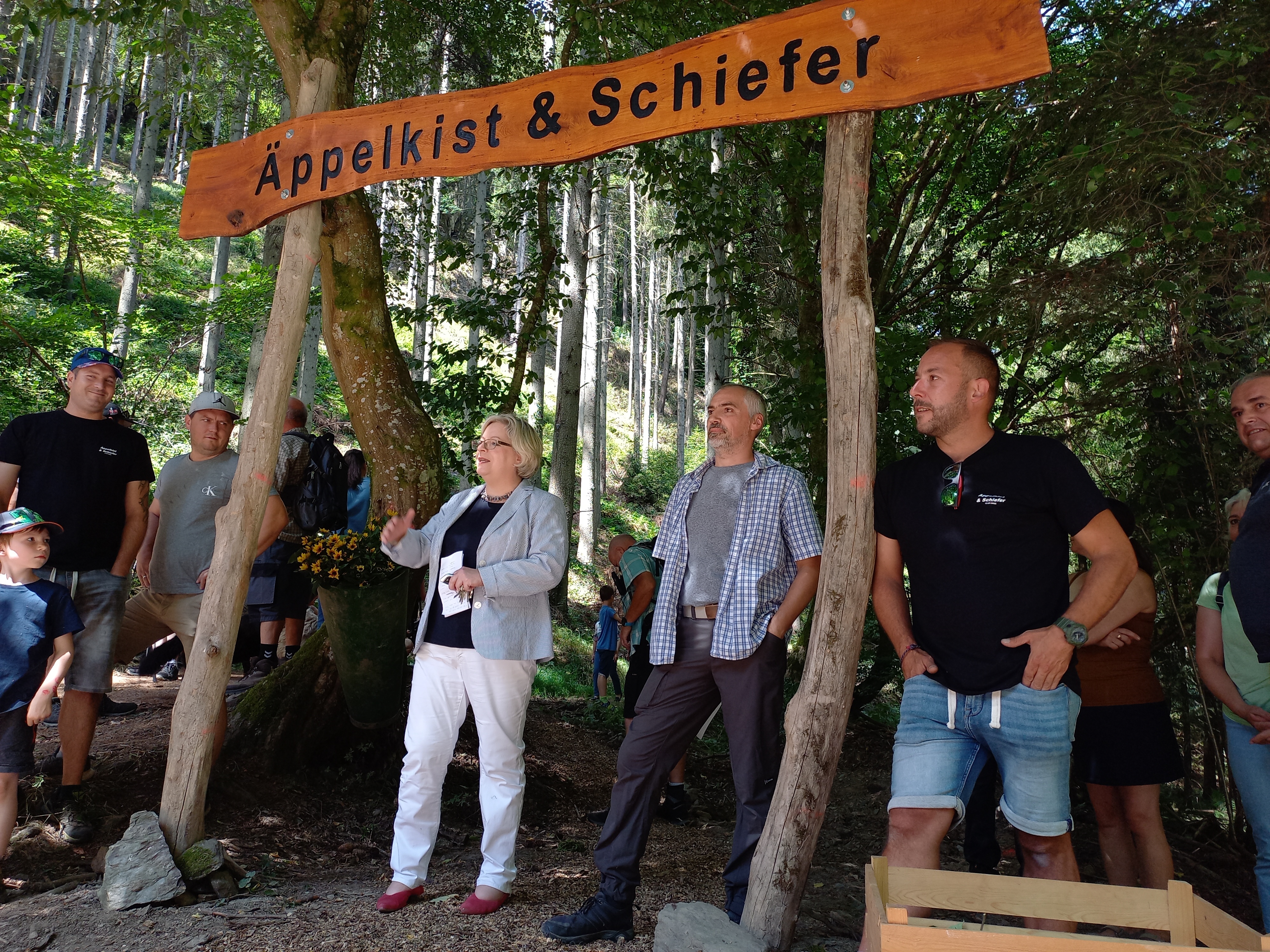 Personen stehen bei einer Wanderwegeröffnung