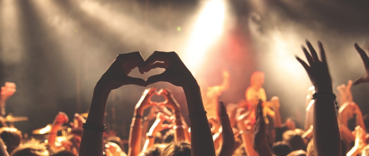 Leute strecken Hände bei einem Konzert in die Höhe