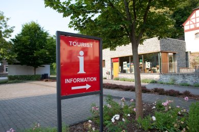 Schild der Touristinformation und im Hintergrund ein Gebäude